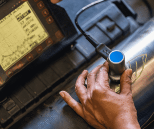 Technician performing ultrasonic NDT testing on industrial component - non-destructive testing services Al Omda Qatar